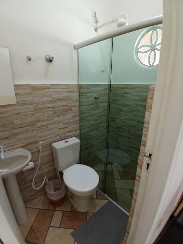 a bathroom with a toilet and a glass shower at Suítes Serra do Cipó 2 in Santana do Riacho