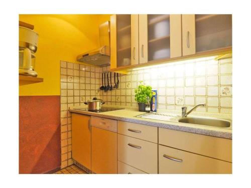 a kitchen with a sink and a counter top at Seestern Comfortable holiday residence in Wittdün