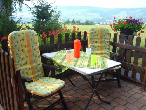 two chairs and a table on a patio at Holiday home by the forest in Olbernhau