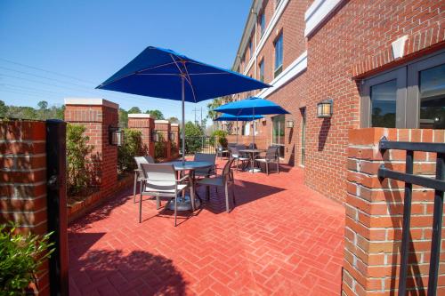 a patio with tables and chairs and umbrellas at Holiday Inn Express Leland - Wilmington Area by IHG in Leland