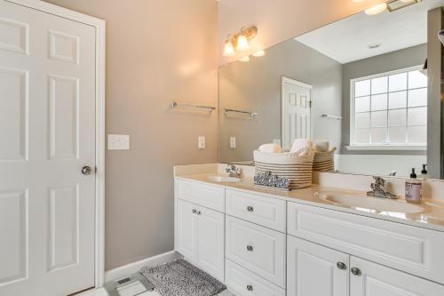 Un baño con dos lavabos y un espejo. en 10 Mi to Augusta Quiet Home with Patio and Yard!, en Graniteville