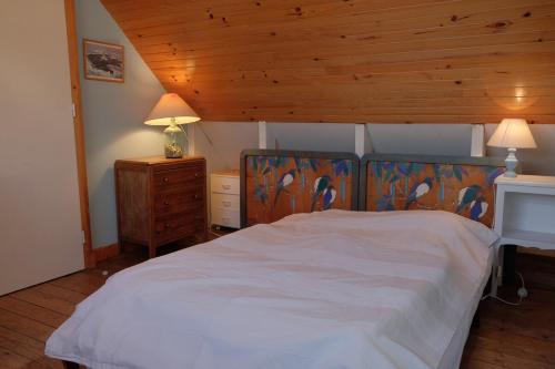 une chambre avec un lit et un plafond en bois dans l'établissement Water front Tradition breton fisherman house, à Carantec