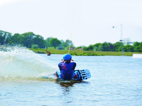 a person on a board in the water at Doppelhaushälften im Ferien- und Freizeitpark Weissenhäuser Strand in Weissenhäuser Strand