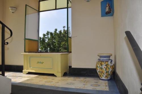 a vase sitting on a table next to a window at Hotel Savoia in Procida