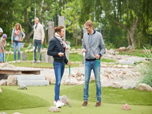 a man and woman playing golf in a park at Appartements im Freizeitpark Weissenhäuser Strand in Weissenhäuser Strand