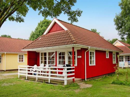a red house with a white fence in front of it at Holiday Park Markgrafenheide Markgrafenheide in Markgrafenheide