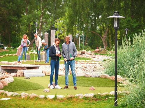 two people standing on a putting green in a park at Appartements im Freizeitpark Weissenhäuser Strand in Weissenhäuser Strand