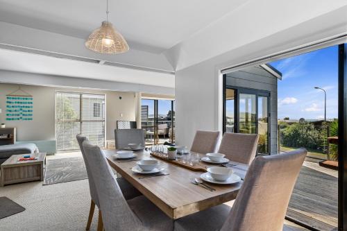a dining room with a wooden table and chairs at Pohara Beach Escape - Pohara Beach Holiday Home in Pohara