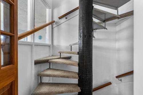 a spiral staircase in a house with a window at Pohara Beach Escape - Pohara Beach Holiday Home in Pohara