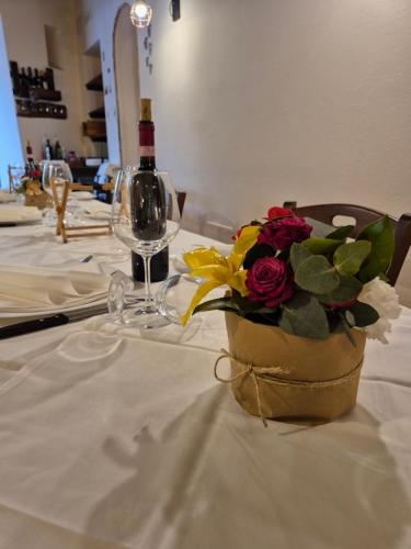 a table with a bottle of wine and a bouquet of flowers at La Finestra d'Arezzo in Arezzo