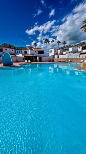 a large blue swimming pool with buildings in the background at Sunny Bungalow with Pool & Patio in Sonnenland By Canarias Prime Homes in Maspalomas