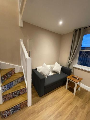 a living room with a couch and a staircase at Low Fellside in Kendal