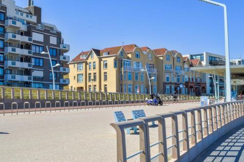 a row of buildings on a beach with a bench at Beach House Rodine - free parking & bikes in Scheveningen
