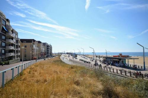 Blick auf einen Strand mit Gebäuden und einem Zaun in der Unterkunft Beach House Rodine - free parking & bikes in Scheveningen