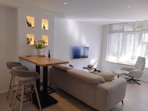 ein Wohnzimmer mit einer Couch und einem Tisch in der Unterkunft Beach House Rodine - free parking & bikes in Scheveningen