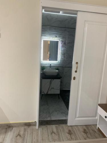 a bathroom with a sink and a mirror at H Flat With Roof- One Kattamya in Cairo