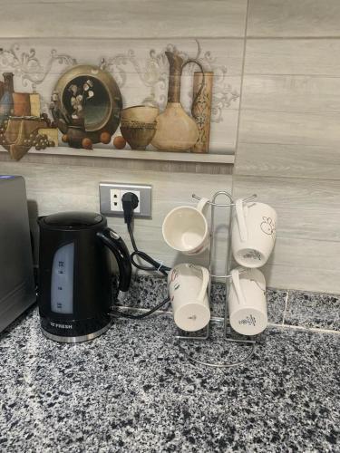 a kitchen counter with a coffee maker and a tea kettle at H Flat With Roof- One Kattamya in Cairo