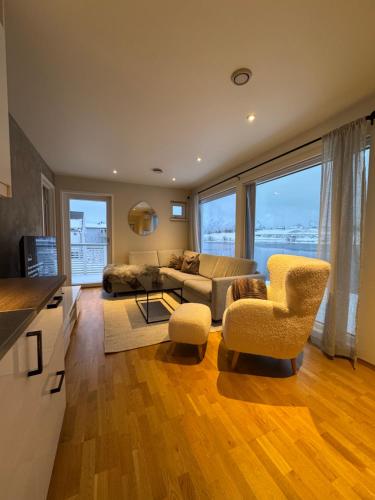 a living room with a couch and a table and chairs at Moderne Leilighet i Lofoten in Leknes