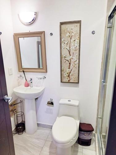 a bathroom with a toilet and a sink and a mirror at Marina Cerritos Azul Turquesa #3 - 4 Albercas - 1 Min Playas in Mazatlán