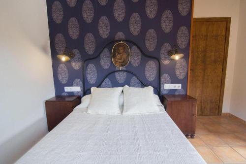 a bedroom with a bed with a blue wall at Casa Mossèn Batista in Les Iglésies