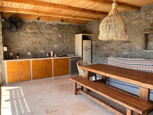 a living room with a wooden table and a kitchen at Kythnian Retreat in Kithnos