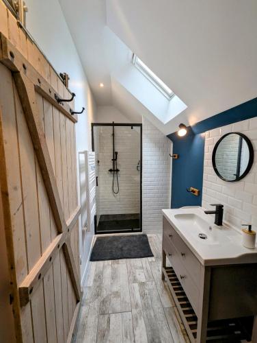 une salle de bain avec une douche, un lavabo et un miroir dans l'établissement Au fil de la Cisse, à Molineuf