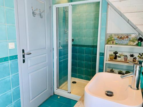 une salle de bain avec douche et lavabo dans l'établissement La Maison Bleue, à Pleumeur-Bodou