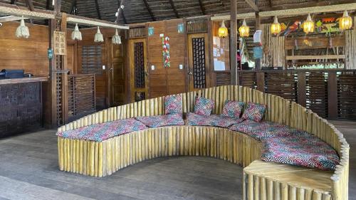 a wooden couch with pillows on it in a room at Hotel Amazon by On Vacation in Leticia
