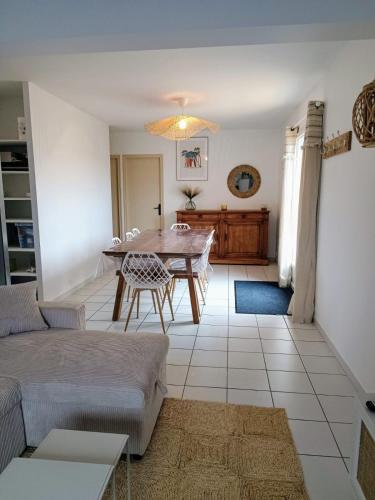 un salon avec une table et un canapé dans l'établissement Maison familiale à 600m de la plage 8mn à pieds, à Saint-Vincent-sur-Jard