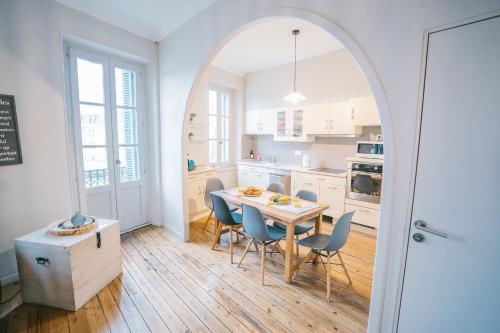 - une cuisine avec une arche, une table et des chaises dans l'établissement Magnifique T4- toit terrasse-Cosy-Centre ville-AA, à Carcassonne