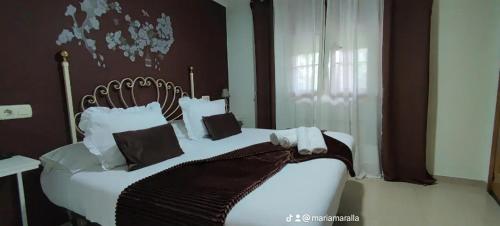 a bedroom with a large bed with black and white pillows at Casa BRAIS in Barreiros