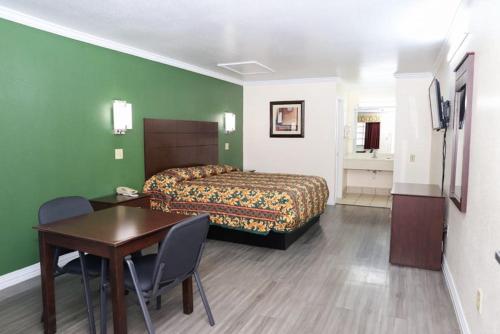 a bedroom with a bed and a table and a table and chairs at Starlite Motel in San Antonio