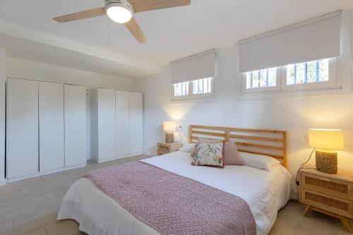 a bedroom with a large bed and two windows at The Urban Mansion by Fidalsa in Alicante
