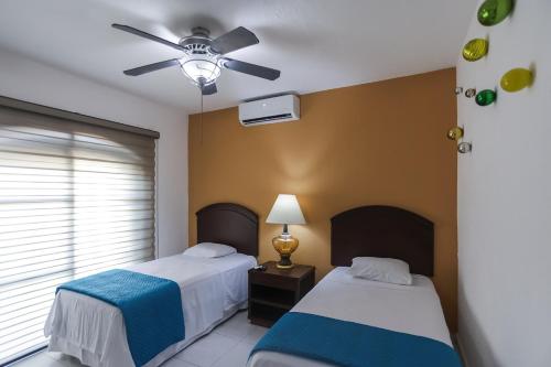a bedroom with two beds and a ceiling fan at Downtown Villa for 7 guests, access to pool! in Cancún