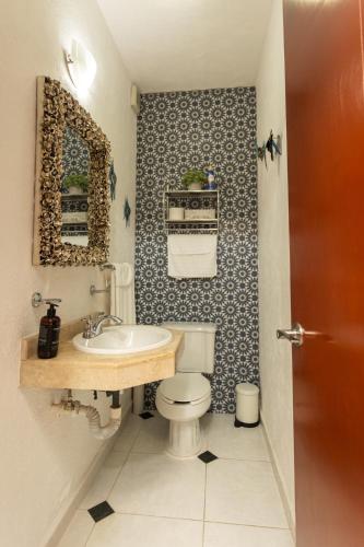 a bathroom with a white toilet and a sink at Downtown Villa for 7 guests, access to pool! in Cancún