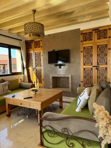 a living room with a couch and a table at Cosy Appartement Avec Piscine, Terrain tennis et loisirs in Marrakech