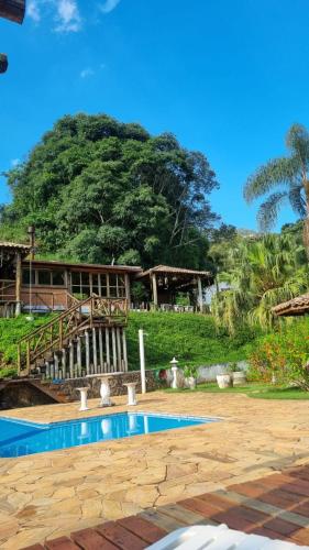 a resort with a swimming pool in front of a building at Pousada Cheiro de Mato in Monte Alegre do Sul