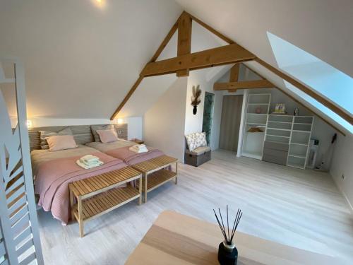 - une chambre mansardée avec un lit et un banc dans l'établissement Domaine Bella Laïta - Gîtes et Chambres D'hôtes, à Clohars-Carnoët