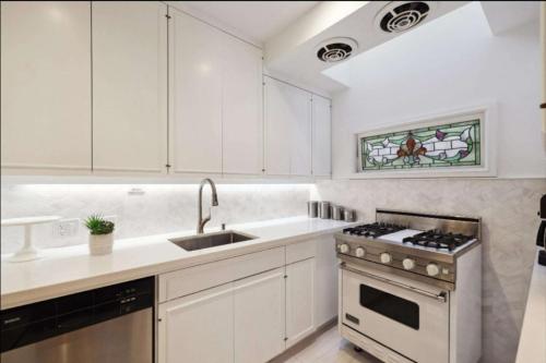 eine weiße Küche mit Herd und Spüle in der Unterkunft Nob Hill Charm in San Francisco