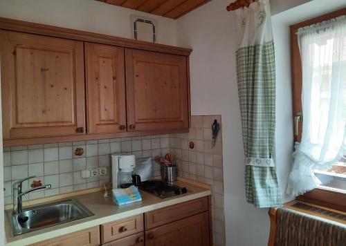 a kitchen with wooden cabinets and a sink at Gästehaus Annemarie in Reit im Winkl