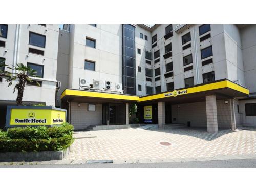 a largeartment building with a yellow sign in front of it at Smile Hotel koriyama - Vacation STAY 61172v in Koriyama