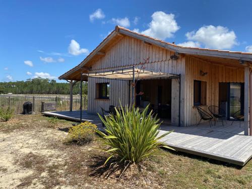 a small house with a porch and a deck at Cabane Alizée, Vensac Océan, Montalivet in Vensac