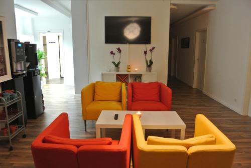 un soggiorno con tavolo e sedie colorate. di MAC City Hostel ad Amburgo