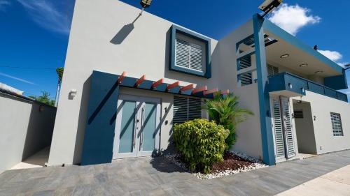 多拉多Private 7 Villa Complex with 16 BR Pool & Jacuzzi的白色和蓝色的房子,有车道