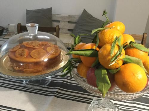 una tavola con due ciotole di arance e un piatto di cibo di B&B Sperlonga a Mattinata