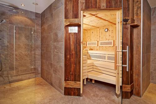a sauna with a shower and a glass door at Andis Almdorf in Sölden