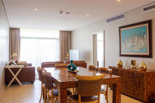 a living room with a wooden table and chairs at Suite 515, Zimbali Suites in Ballito