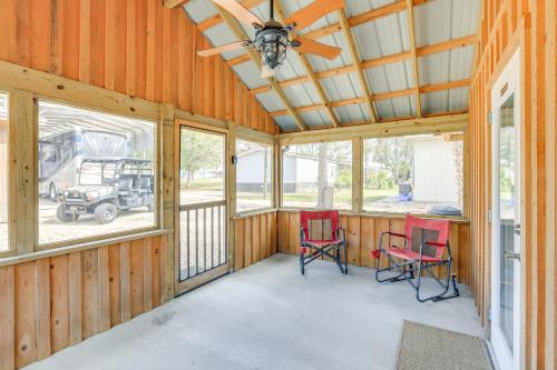 a large room with two red chairs and windows at Near Steinhatchee River Studio with Screened Porch! in Steinhatchee