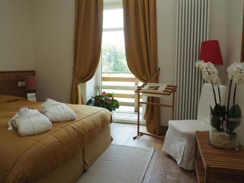 a hotel room with a bed and a window at Maloja Palace Residence Engadin-St Moritz CO2-Neutral in Maloja