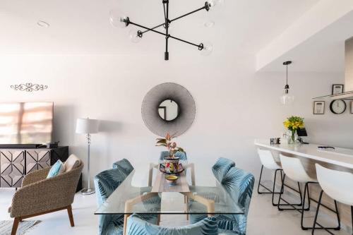 a living room with a glass table and chairs at Casa Cabo - THE BEST, fully equipped luxurious brand new condo in Cabo San Lucas